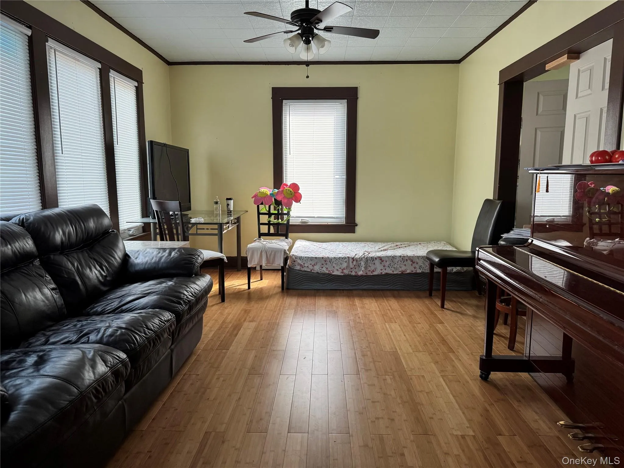 Bedroom featuring crown molding, wood finished floors, and a ceiling fan Bedroom featuring crown molding, wood finished floors, and a ceiling fan