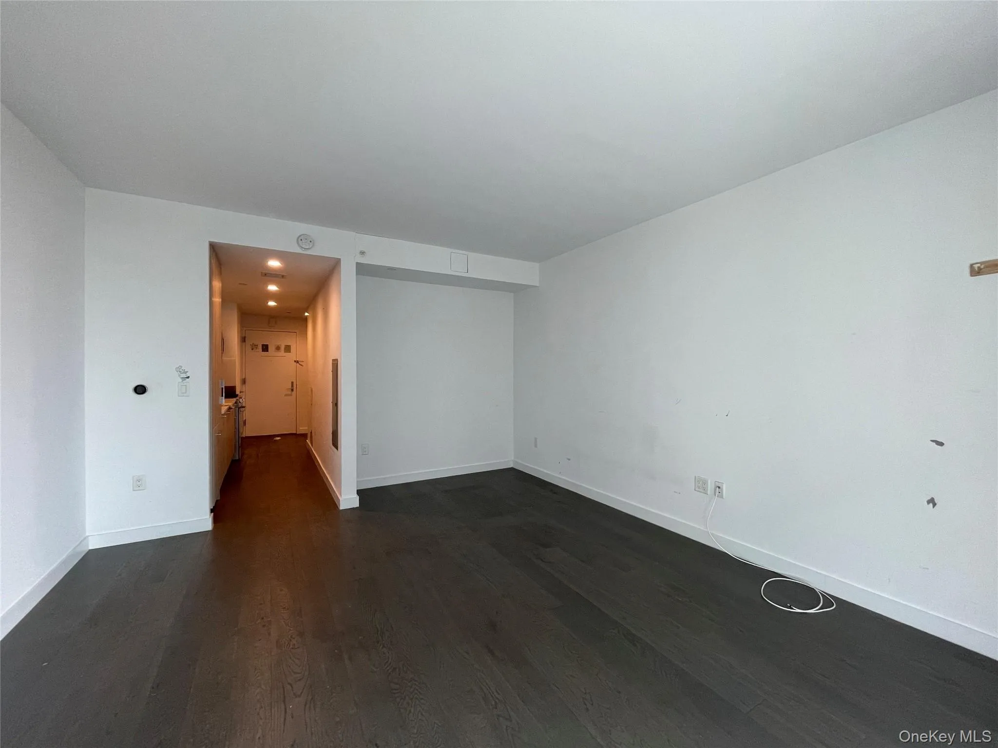 Empty room featuring dark wood-style flooring and recessed lighting Empty room featuring dark wood-style flooring and recessed lighting