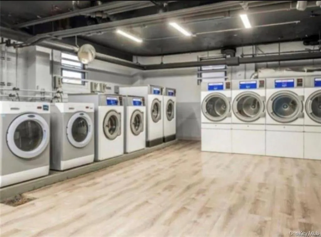 Laundry room featuring washer and clothes dryer and light wood-type flooring Laundry room featuring washer and clothes dryer and light wood-type flooring