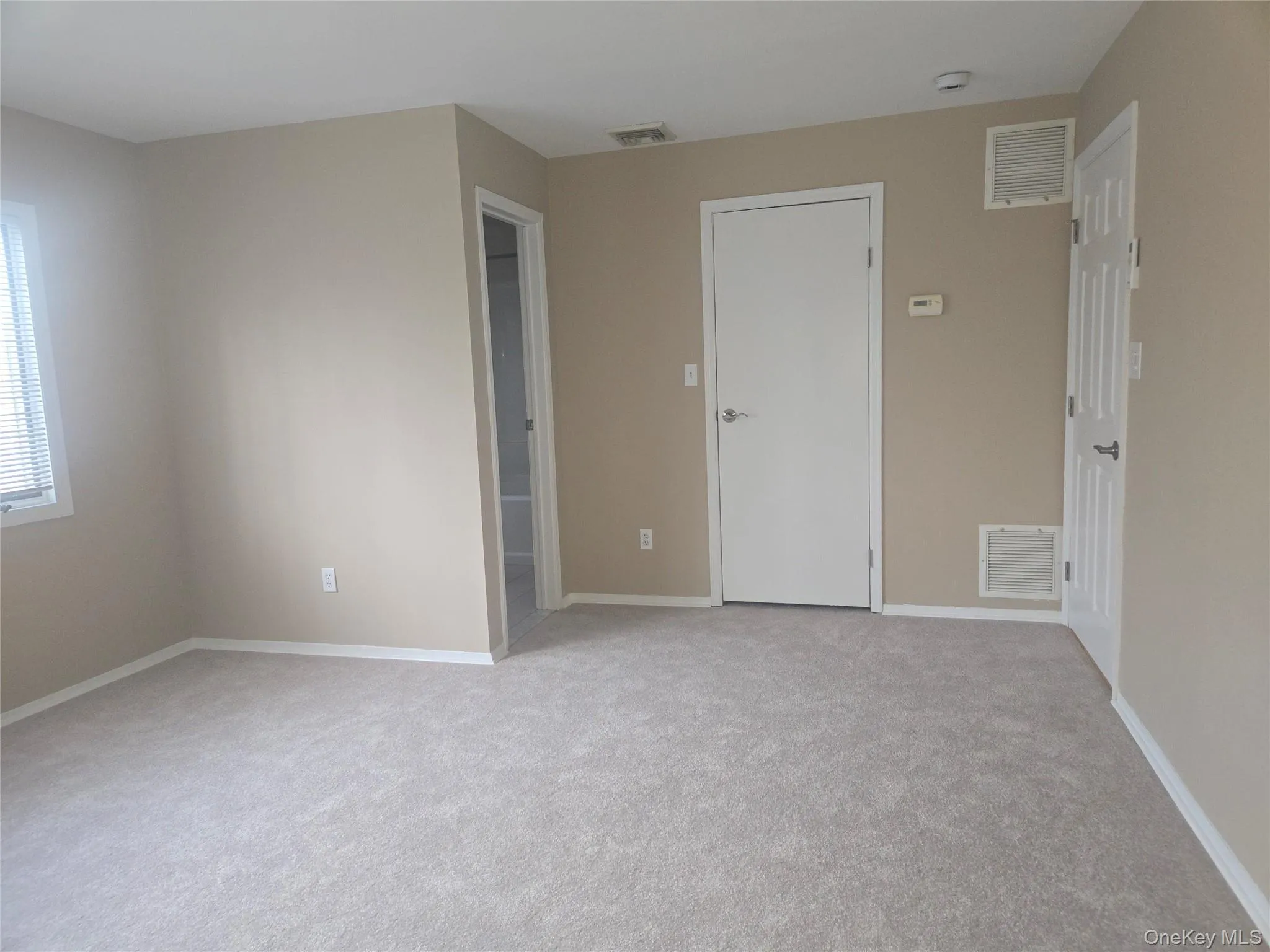 Spare room featuring light carpet and baseboards Spare room featuring light carpet and baseboards