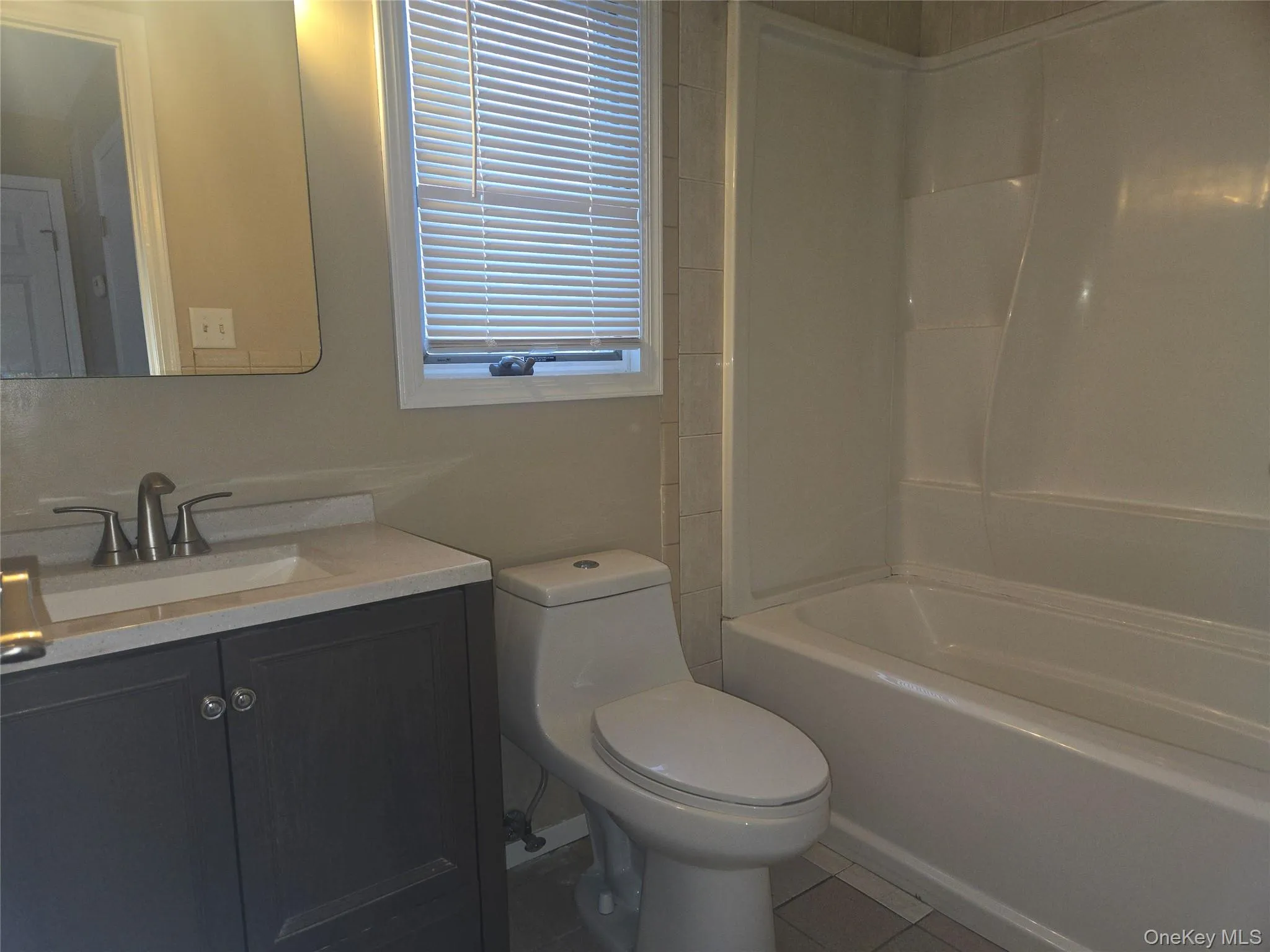 Full bathroom with vanity, shower / bath combination, and light tile patterned flooring Full bathroom with vanity, shower / bath combination, and light tile patterned flooring