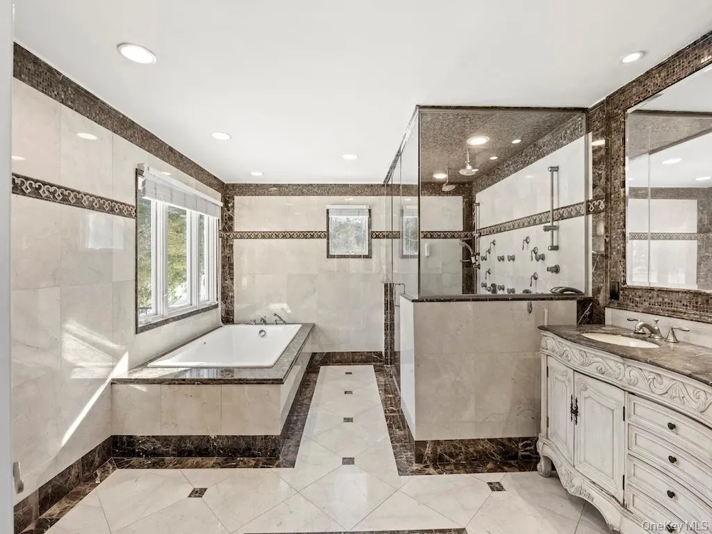 A spacious 11x14 full bathroom features a dual-person walk-in shower equipped with multiple shower jets and a rain showerhead. Additionally, the bathroom includes a double sink. A spacious 11x14 full bathroom features a dual-person walk-in shower equipped with multiple shower jets and a rain showerhead. Additionally, the bathroom includes a double sink.