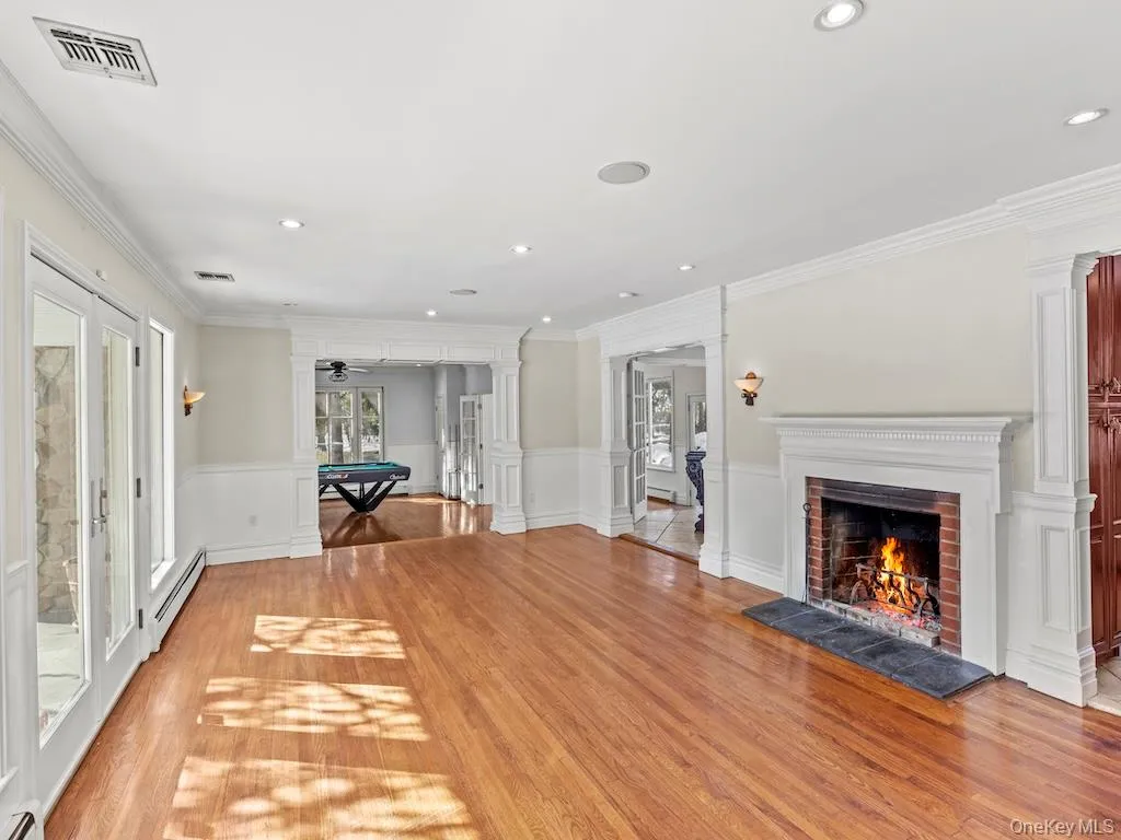 The spacious living room is adorned with a fireplace and recessed lighting. A French door provides access to the front patio. The spacious living room is adorned with a fireplace and recessed lighting. A French door provides access to the front patio.