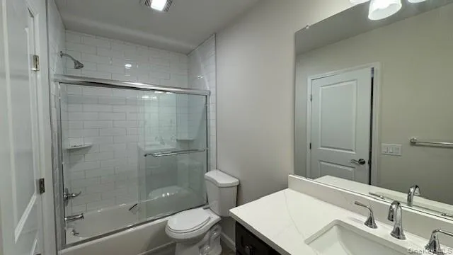 Main Full bathroom featuring vanity, bath / shower combo with glass door, and toilet Main Full bathroom featuring vanity, bath / shower combo with glass door, and toilet