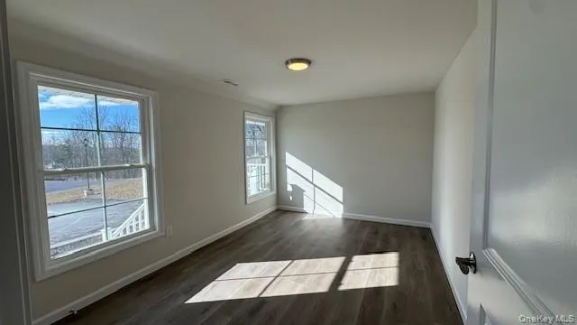 Empty room with dark hardwood / wood-style floors Empty room with dark hardwood / wood-style floors