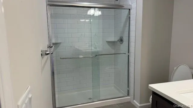 Primary Bathroom with toilet, vanity, tile patterned floors, and an enclosed shower Primary Bathroom with toilet, vanity, tile patterned floors, and an enclosed shower