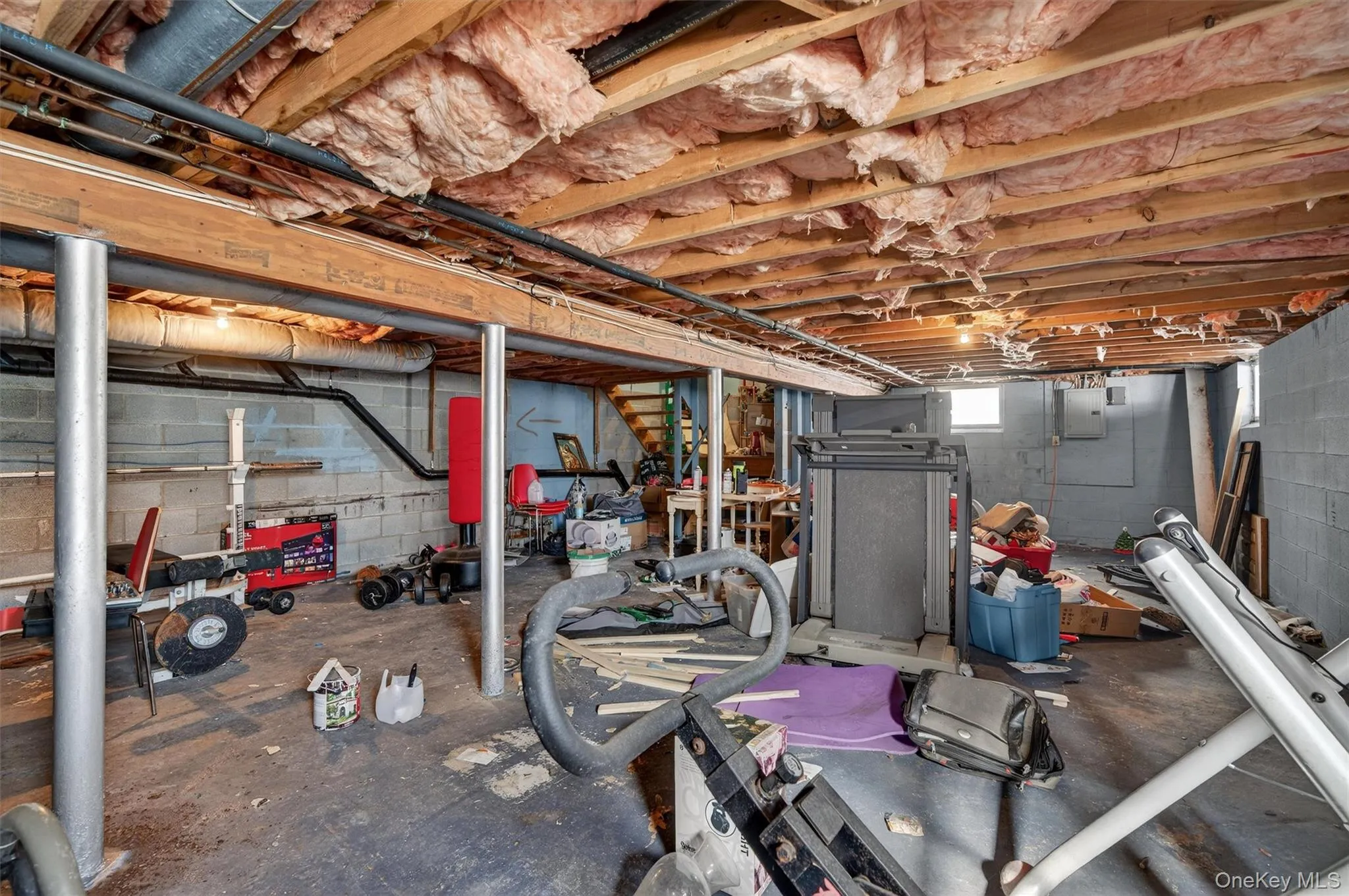 Below grade area featuring stairway and electric panel Below grade area featuring stairway and electric panel