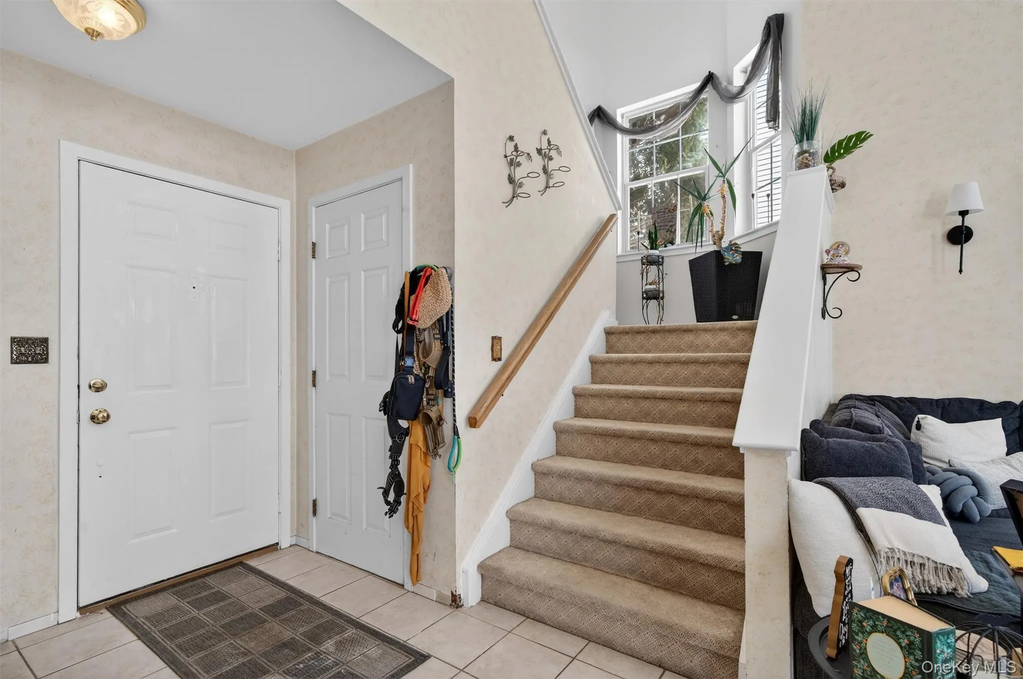 Foyer entrance featuring stairs and light tile patterned floors Foyer entrance featuring stairs and light tile patterned floors