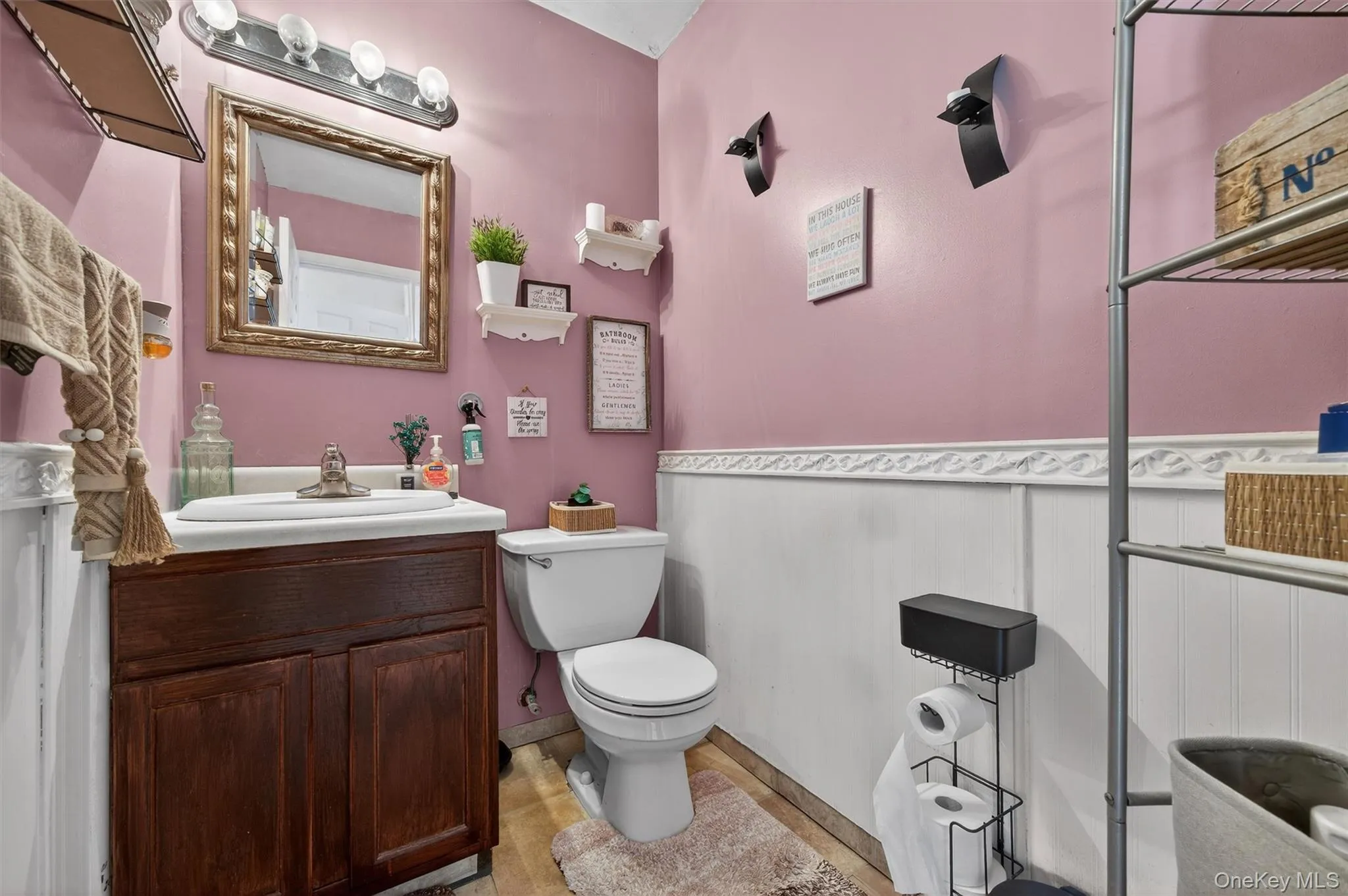 Half bath featuring vanity and wainscoting Half bath featuring vanity and wainscoting