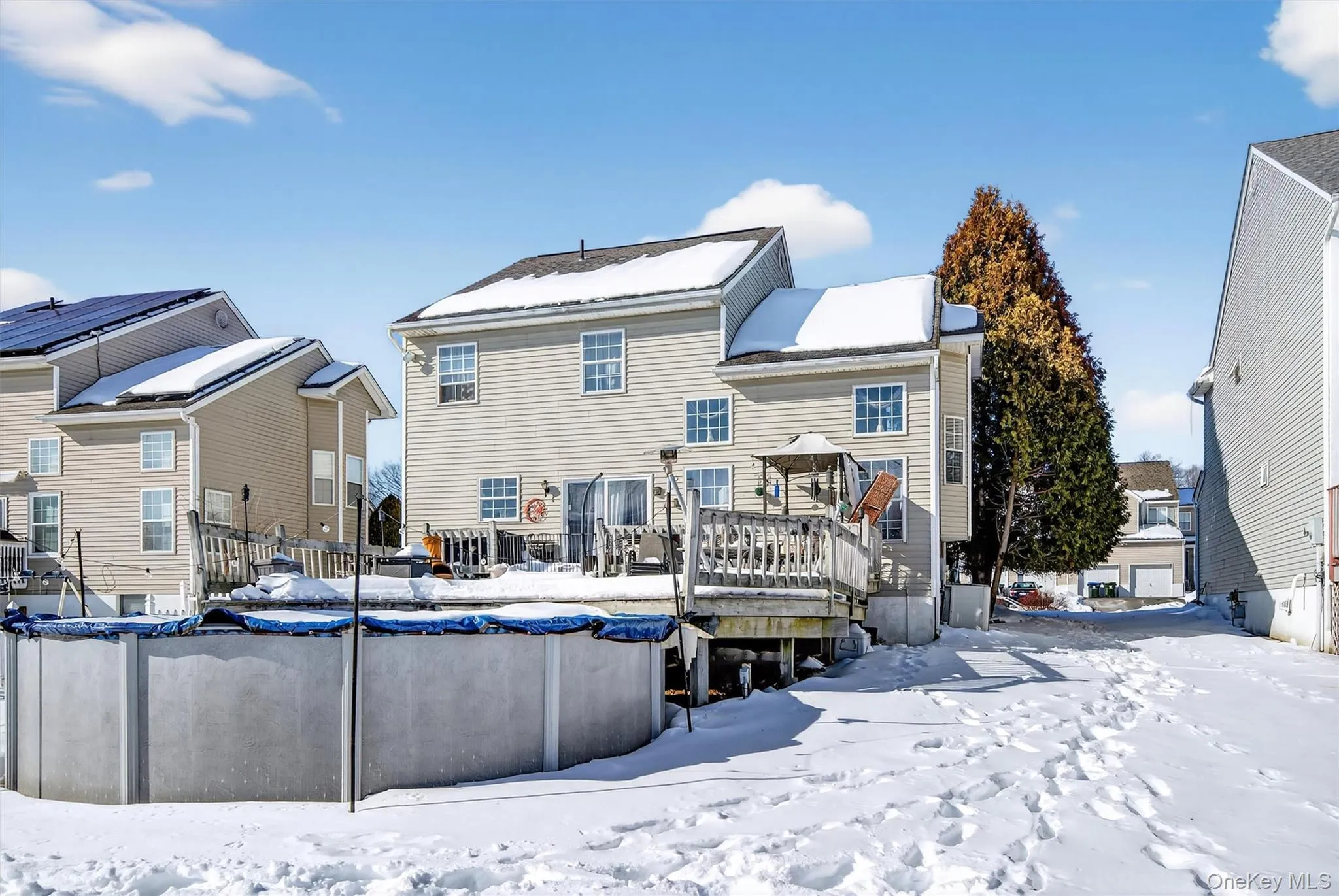 Snow covered house featuring a deck, a covered pool, and a gazebo Snow covered house featuring a deck, a covered pool, and a gazebo