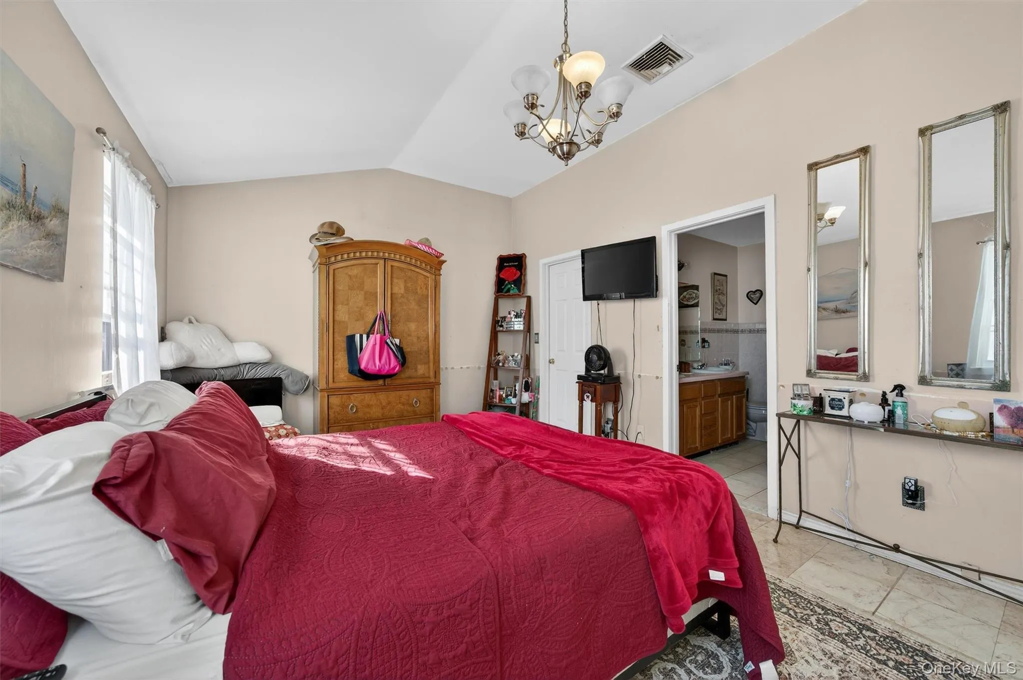 Bedroom with hanging lights, lofted ceiling, a closet, and connected bathroom Bedroom with hanging lights, lofted ceiling, a closet, and connected bathroom