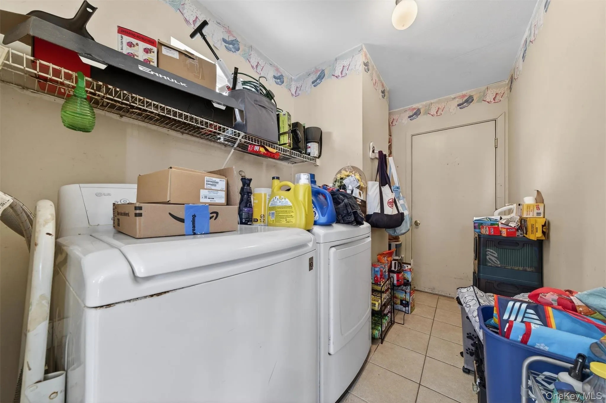 Laundry area featuring washing machine and clothes dryer and light tile patterned flooring Laundry area featuring washing machine and clothes dryer and light tile patterned flooring