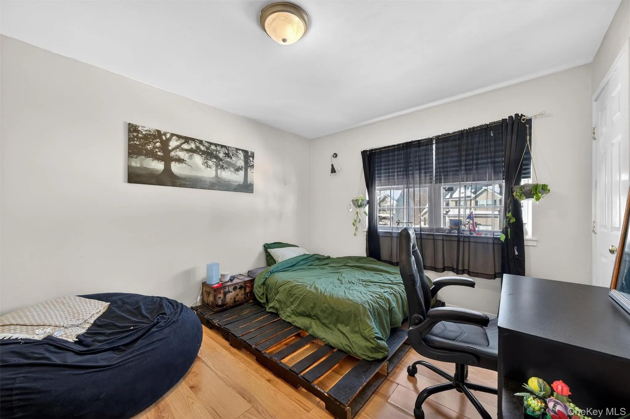 Bedroom featuring wood finished floors and a desk Bedroom featuring wood finished floors and a desk