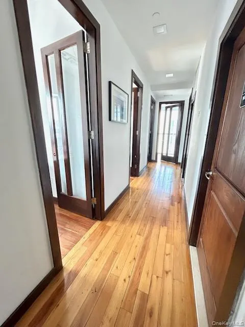 Corridor with baseboards and light wood-style flooring Corridor with baseboards and light wood-style flooring