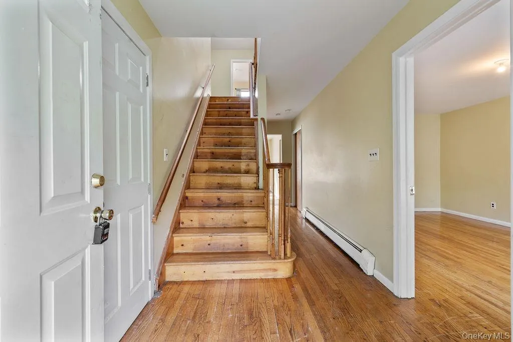 Stairway with a baseboard radiator and wood-type flooring Stairway with a baseboard radiator and wood-type flooring