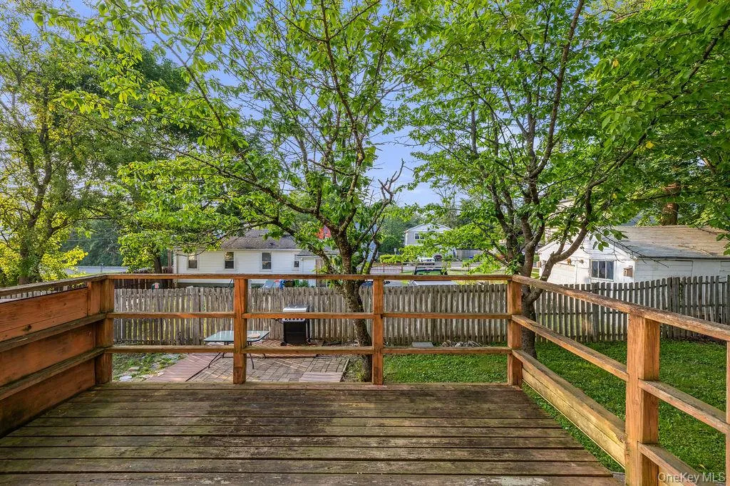 Wooden terrace featuring a fenced backyard and a residential view Wooden terrace featuring a fenced backyard and a residential view