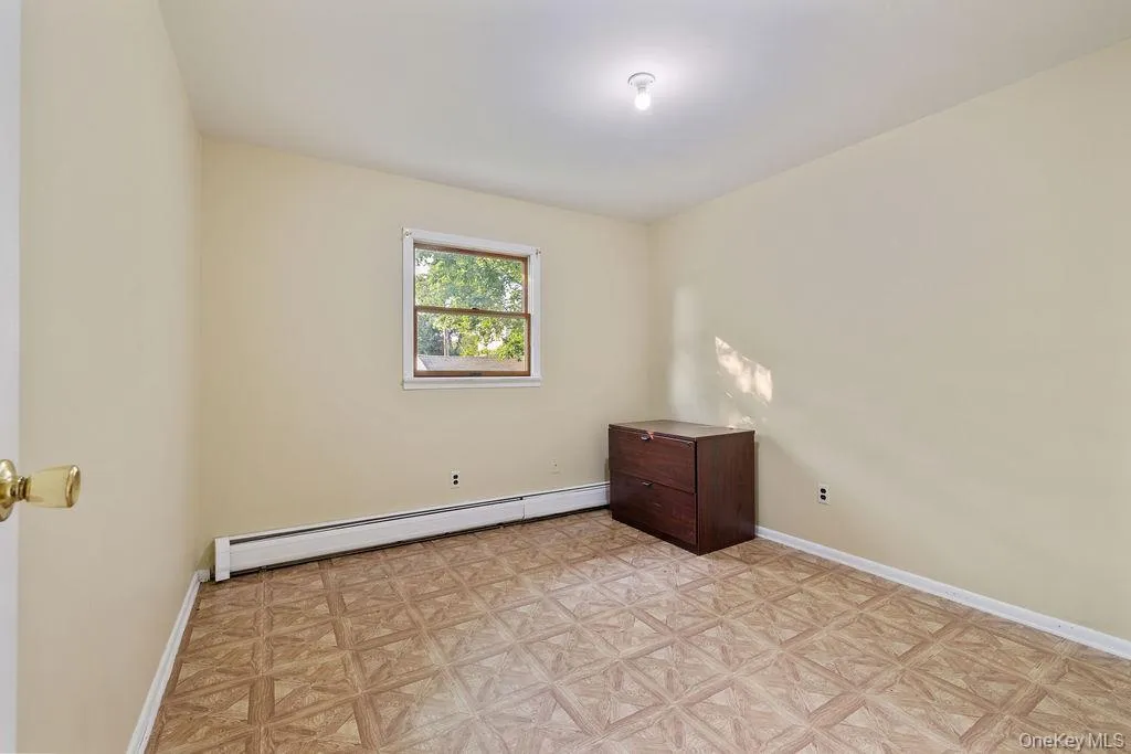 Empty room with a baseboard radiator and baseboards Empty room with a baseboard radiator and baseboards