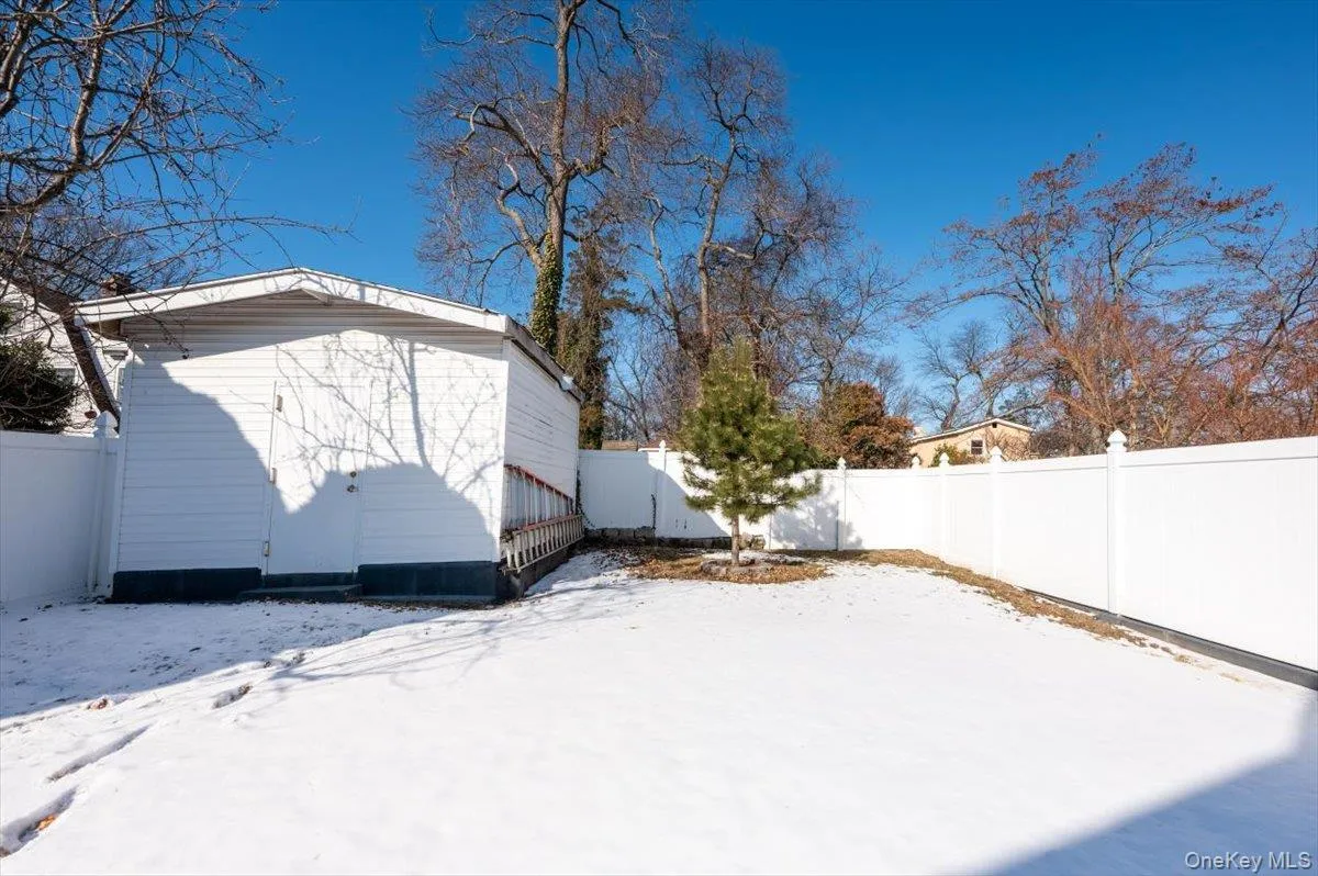 Yard layered in snow with a fenced backyard Yard layered in snow with a fenced backyard