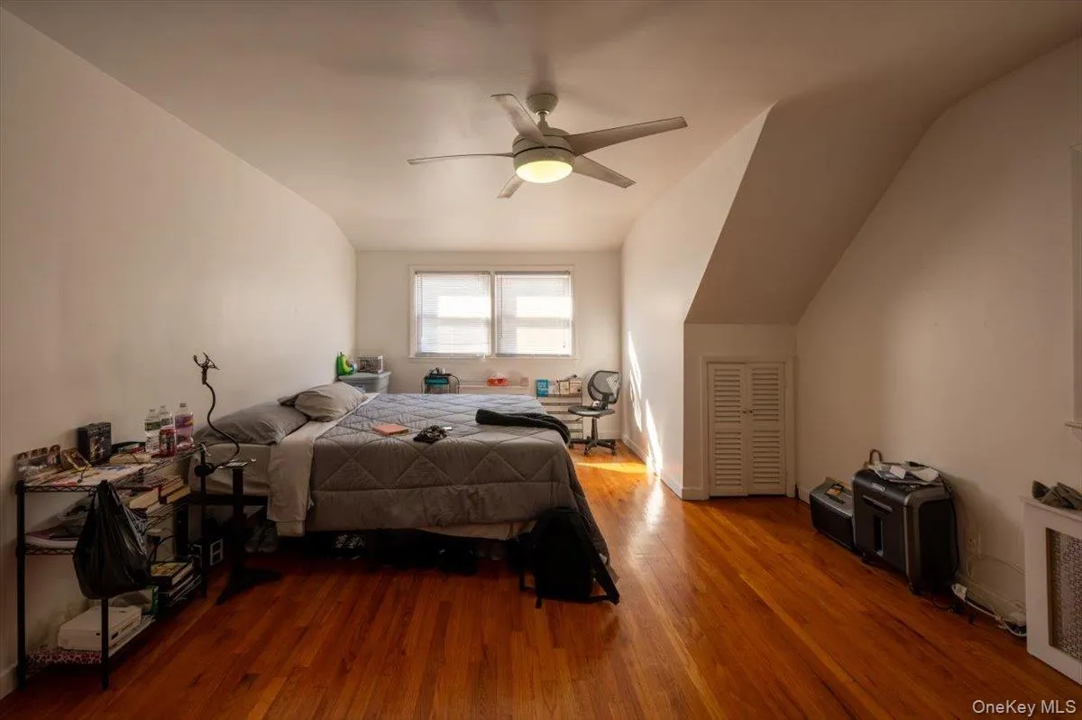 Bedroom featuring wood finished floors, vaulted ceiling, and ceiling fan Bedroom featuring wood finished floors, vaulted ceiling, and ceiling fan
