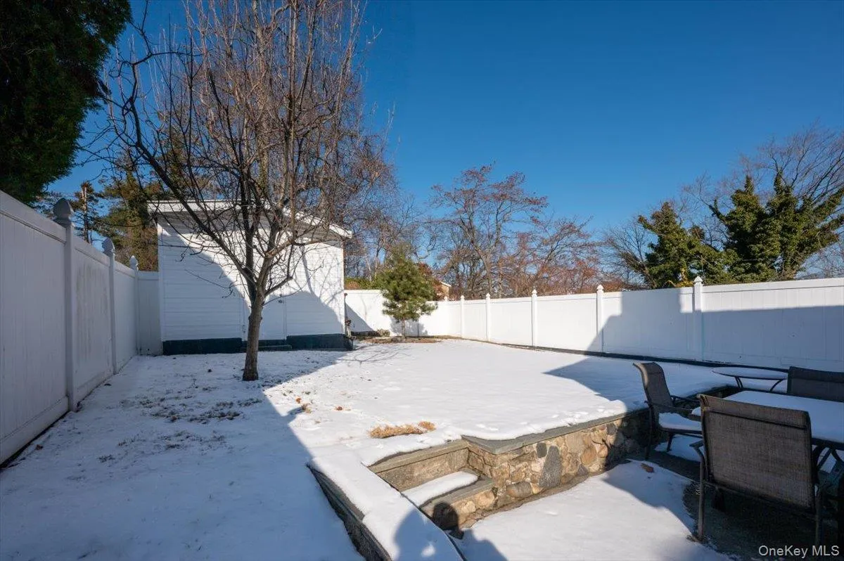 Snow covered patio with a fenced backyard and a patio Snow covered patio with a fenced backyard and a patio