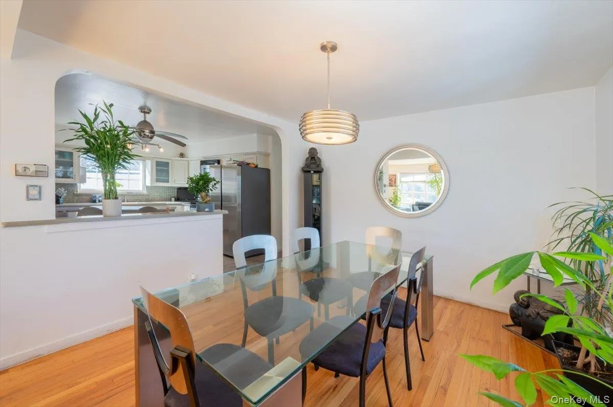 Dining room featuring arched walkways, light wood-style flooring, and ceiling fan Dining room featuring arched walkways, light wood-style flooring, and ceiling fan