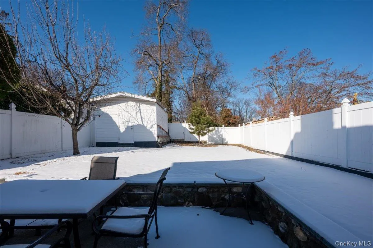 Snow covered patio featuring a fenced backyard and a storage unit Snow covered patio featuring a fenced backyard and a storage unit