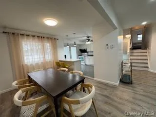 Dining area with stairs, wood finished floors, baseboards, and ceiling fan Dining area with stairs, wood finished floors, baseboards, and ceiling fan