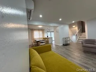 Bedroom featuring recessed lighting, wood finished floors, baseboards, and a wall mounted AC Bedroom featuring recessed lighting, wood finished floors, baseboards, and a wall mounted AC
