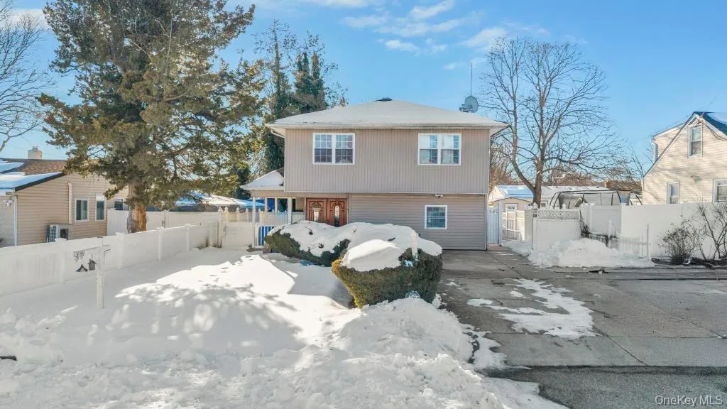 Snow covered rear of property with a gate Snow covered rear of property with a gate