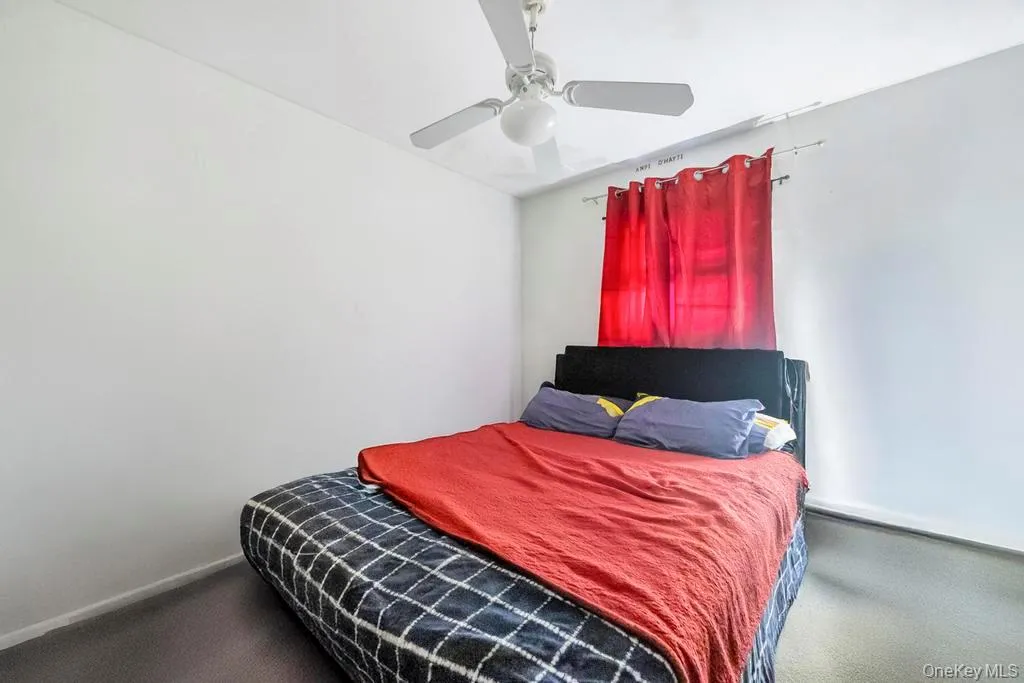 Carpeted bedroom with a ceiling fan Carpeted bedroom with a ceiling fan