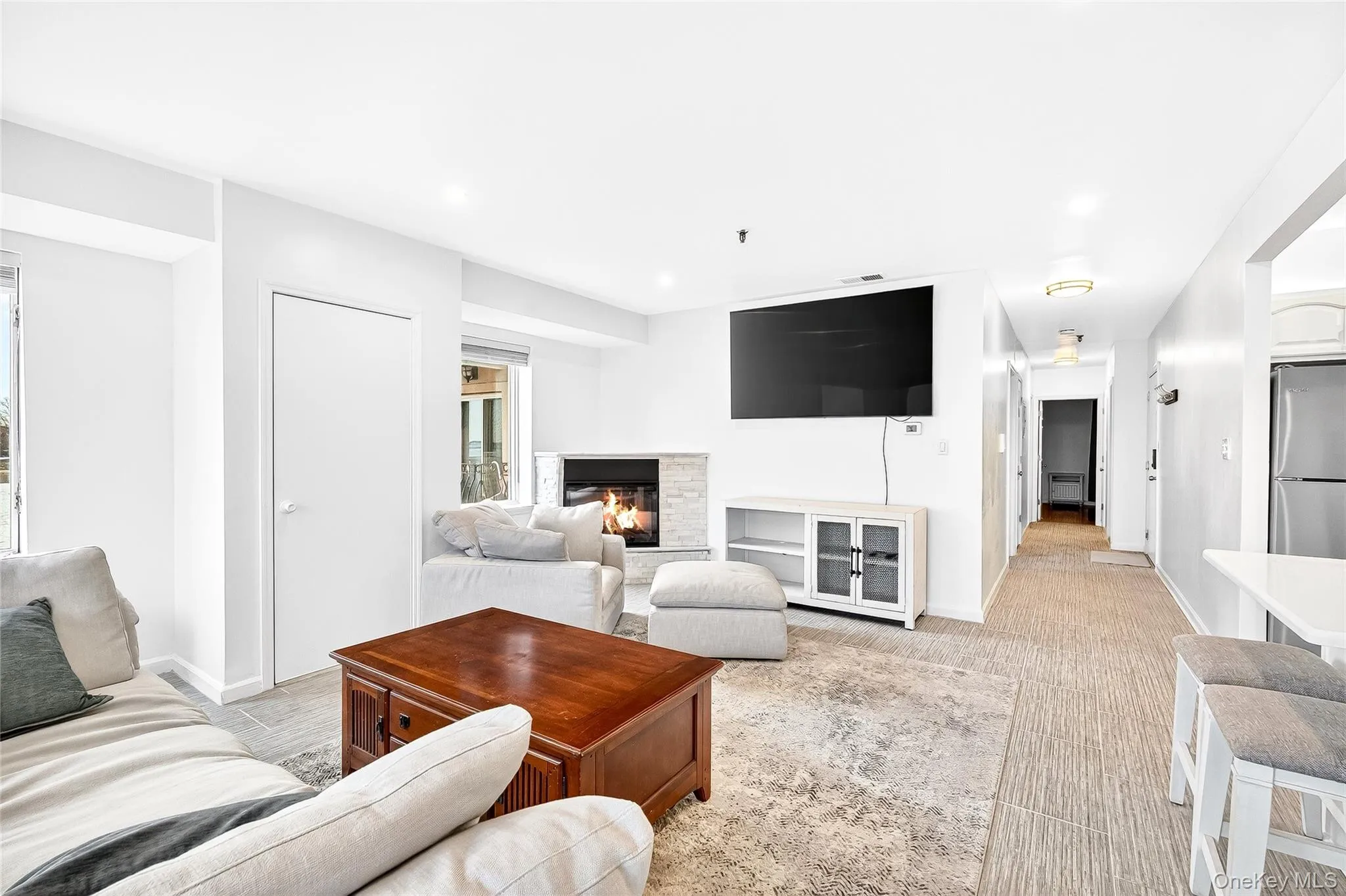 Living area with a glass covered, electric fireplace and recessed lighting Living area with a glass covered, electric fireplace and recessed lighting