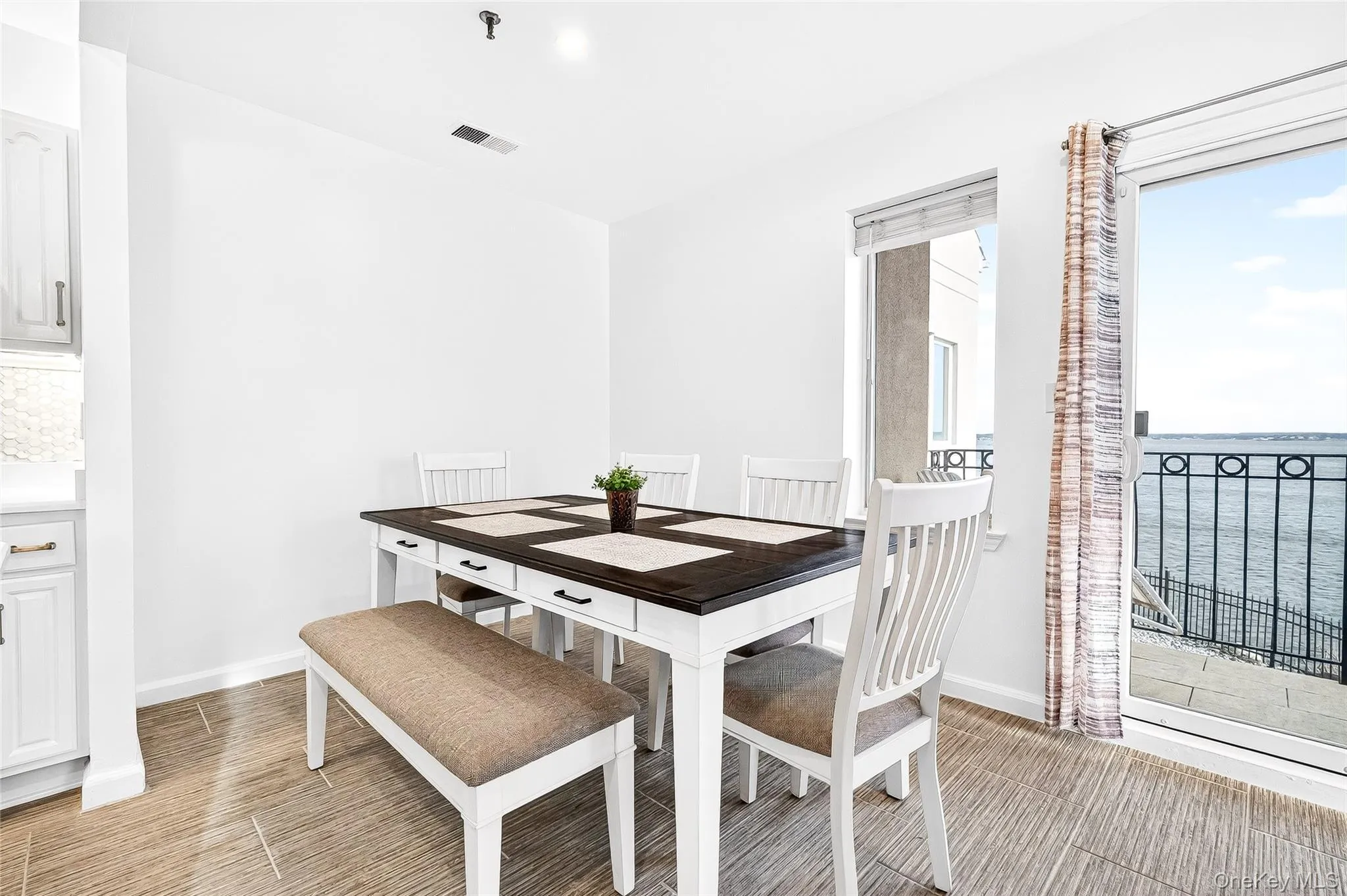 Dining area with a water view and wood tiled floors Dining area with a water view and wood tiled floors