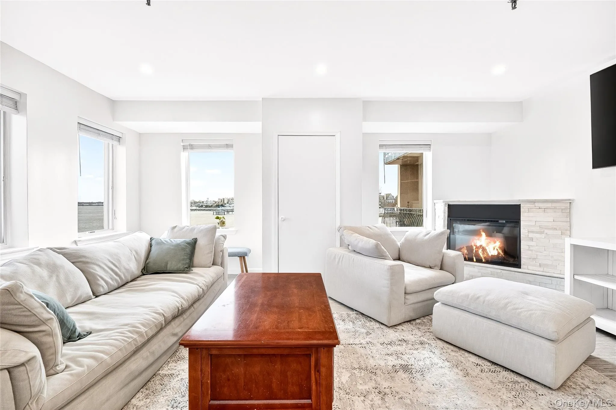 Living room with recessed lighting and a glass covered electric fireplace Living room with recessed lighting and a glass covered electric fireplace
