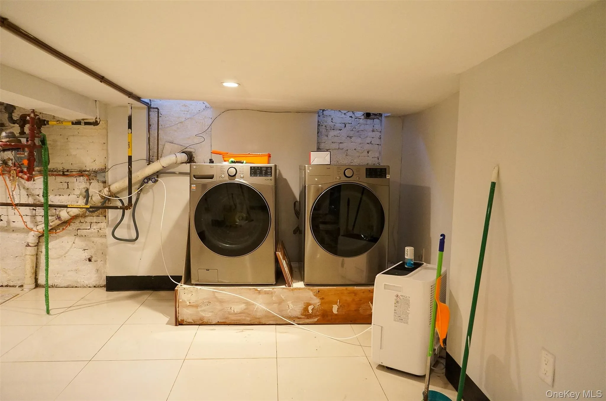 Laundry room with tile patterned flooring, washing machine and clothes dryer, and recessed lighting Laundry room with tile patterned flooring, washing machine and clothes dryer, and recessed lighting
