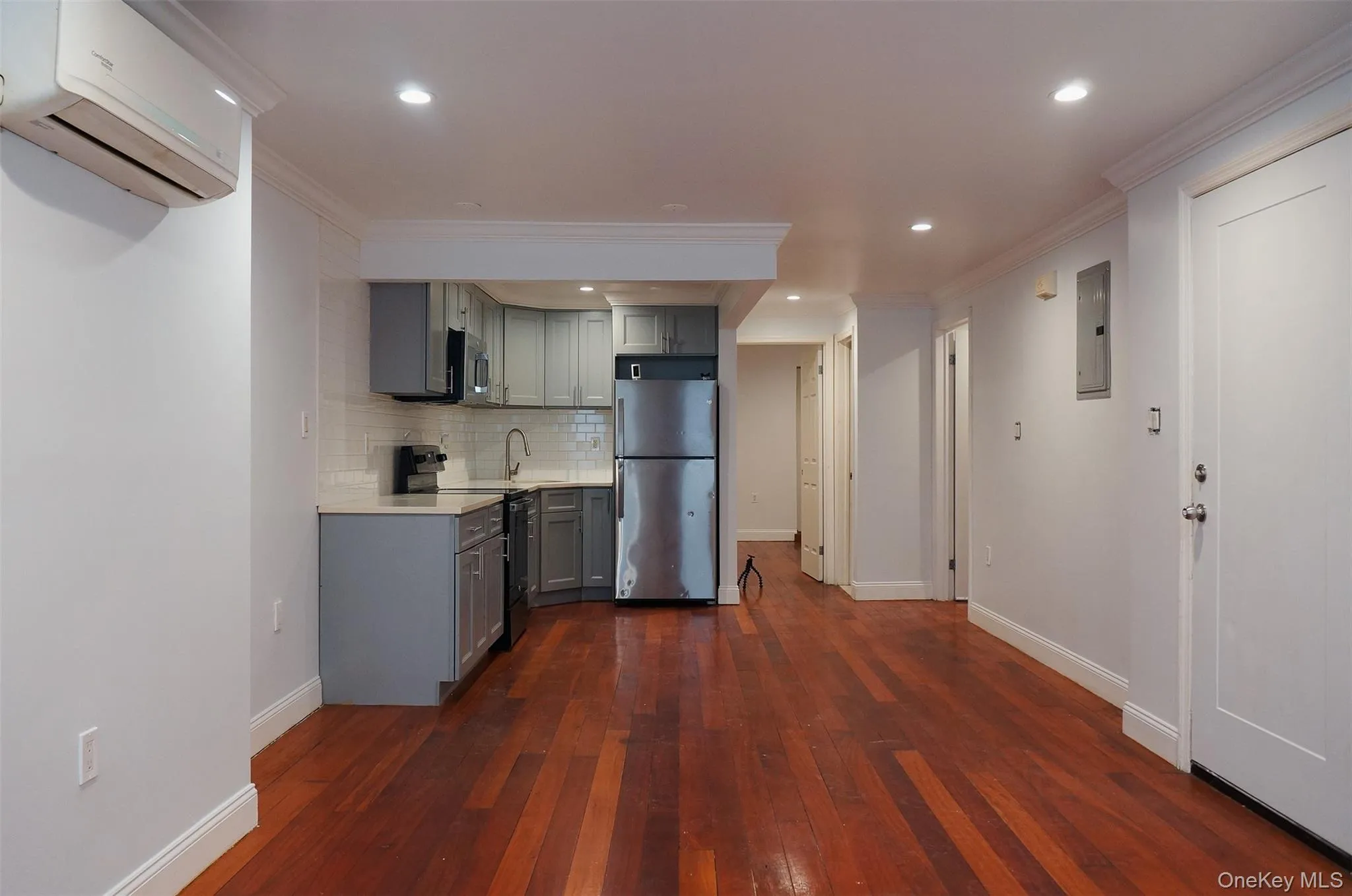 Kitchen with gray cabinets, ornamental molding, light countertops, electric range, and freestanding refrigerator Kitchen with gray cabinets, ornamental molding, light countertops, electric range, and freestanding refrigerator