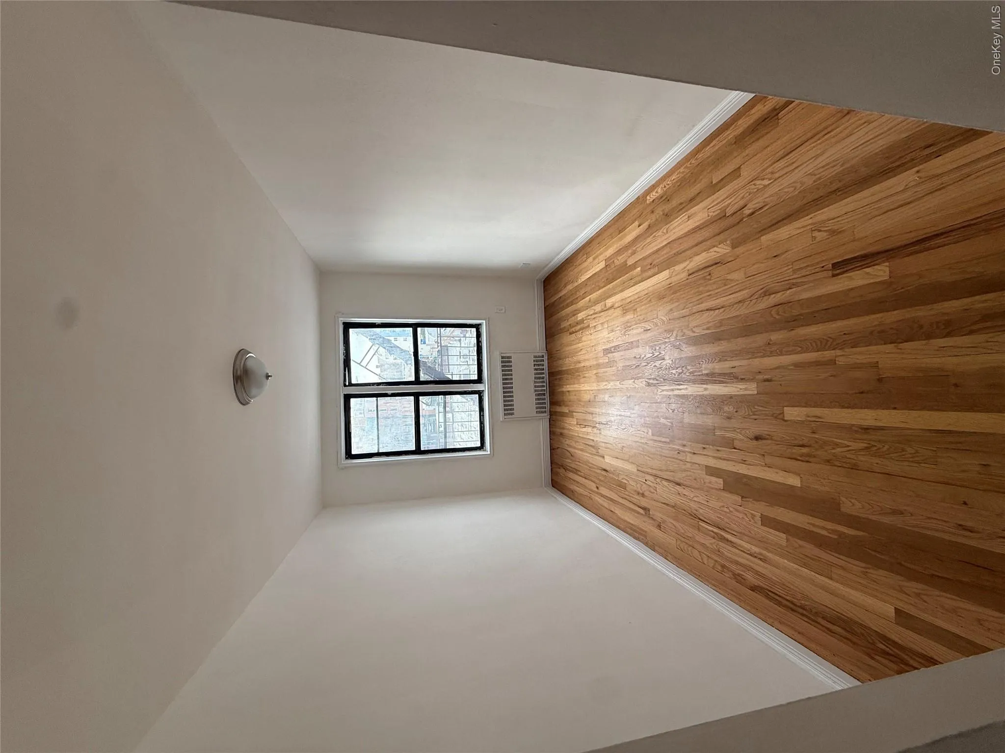 Bedroom with light wood floors and radiator heating unit Bedroom with light wood floors and radiator heating unit