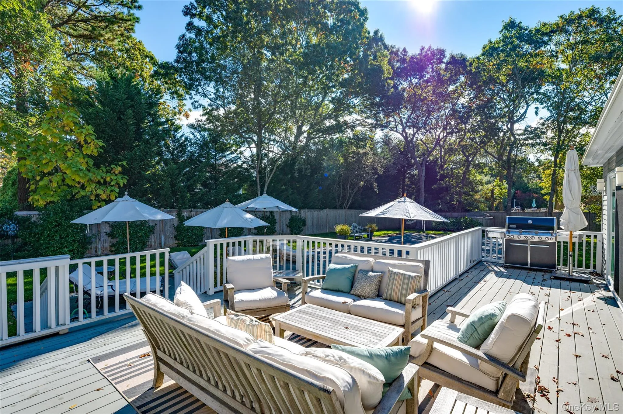 Wooden deck with area for grilling and an outdoor hangout area Wooden deck with area for grilling and an outdoor hangout area