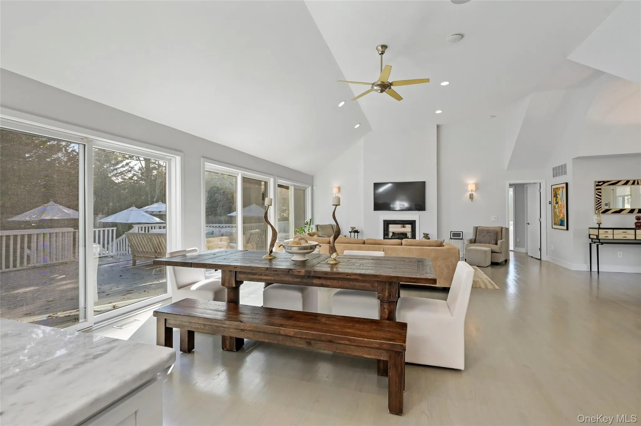 Dining area featuring ceiling fan, light wood-type flooring, and high vaulted ceiling Dining area featuring ceiling fan, light wood-type flooring, and high vaulted ceiling