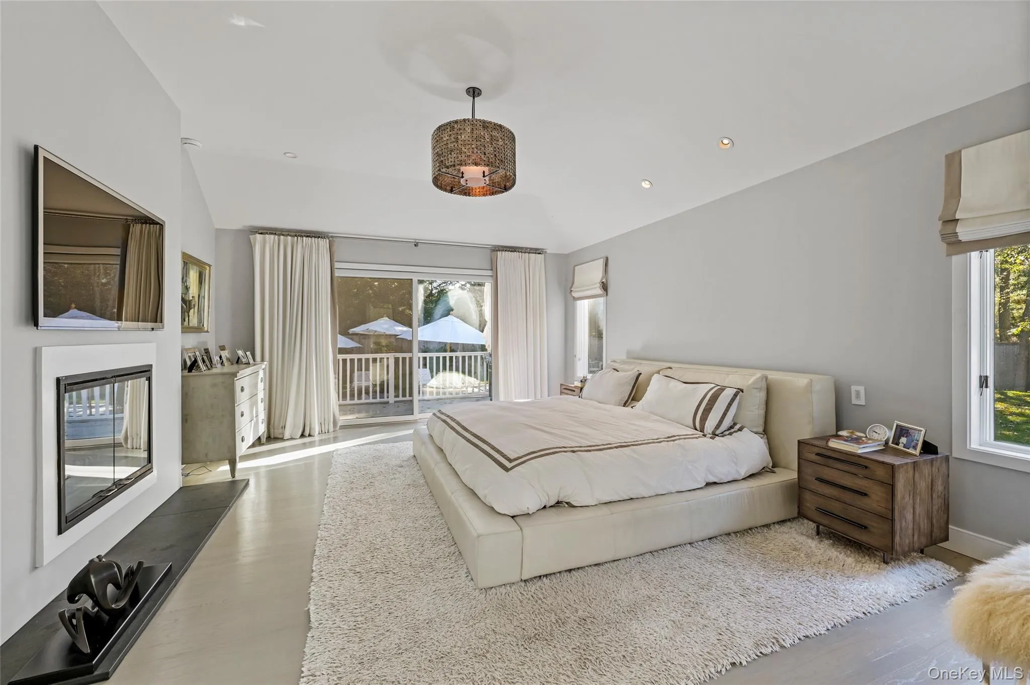 Bedroom with multiple windows, vaulted ceiling, hardwood / wood-style flooring, and access to outside Bedroom with multiple windows, vaulted ceiling, hardwood / wood-style flooring, and access to outside