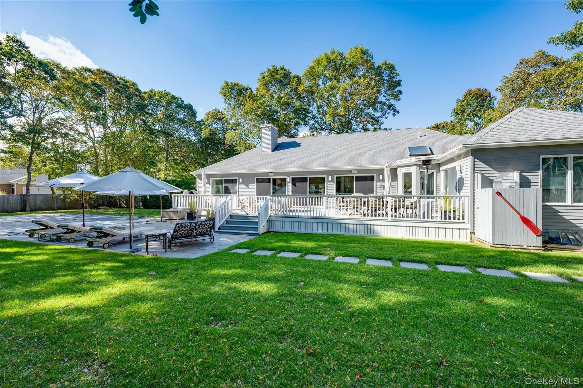Rear view of house with a yard, a deck, and a patio Rear view of house with a yard, a deck, and a patio