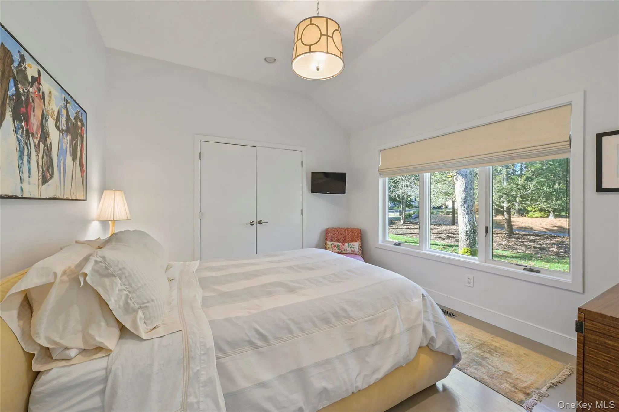Bedroom with vaulted ceiling, hardwood / wood-style floors, and a closet Bedroom with vaulted ceiling, hardwood / wood-style floors, and a closet
