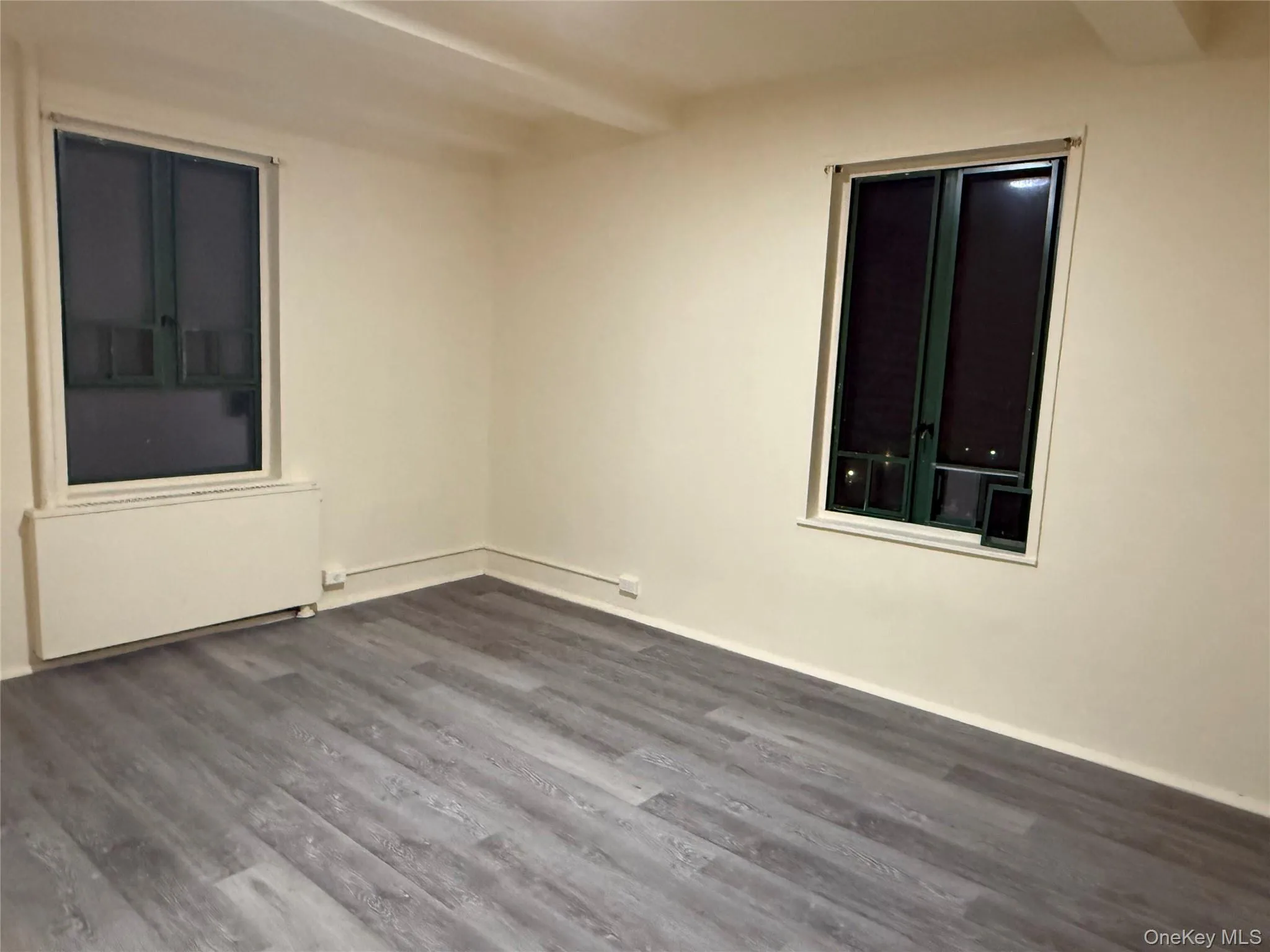 Bedroom featuring dark wood-type flooring and radiator Bedroom featuring dark wood-type flooring and radiator