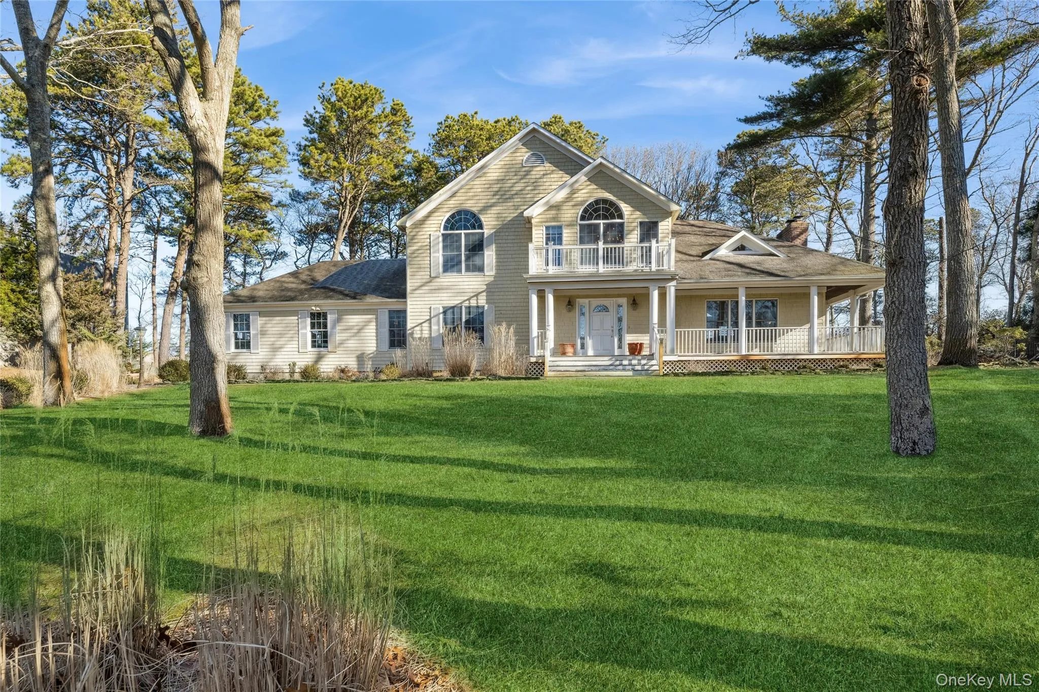 View of front of home featuring a balcony, a chimney, a porch, a front yard, and roof with shingles View of front of home featuring a balcony, a chimney, a porch, a front yard, and roof with shingles