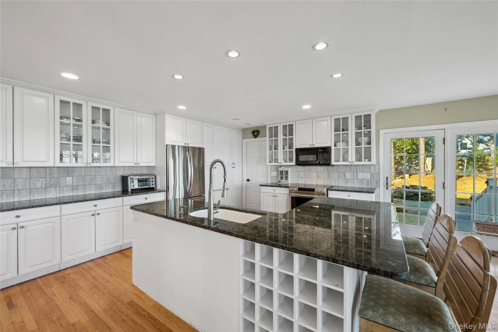 Kitchen with appliances with stainless steel finishes, tasteful backsplash, a sink, and recessed lighting Kitchen with appliances with stainless steel finishes, tasteful backsplash, a sink, and recessed lighting