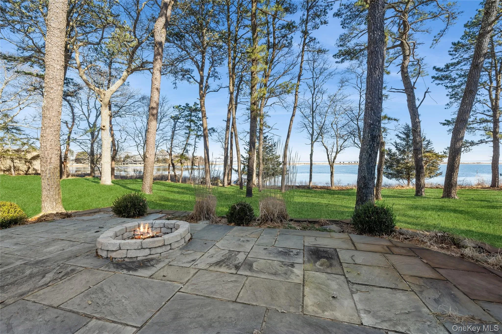View of patio with a water view and an outdoor fire pit View of patio with a water view and an outdoor fire pit