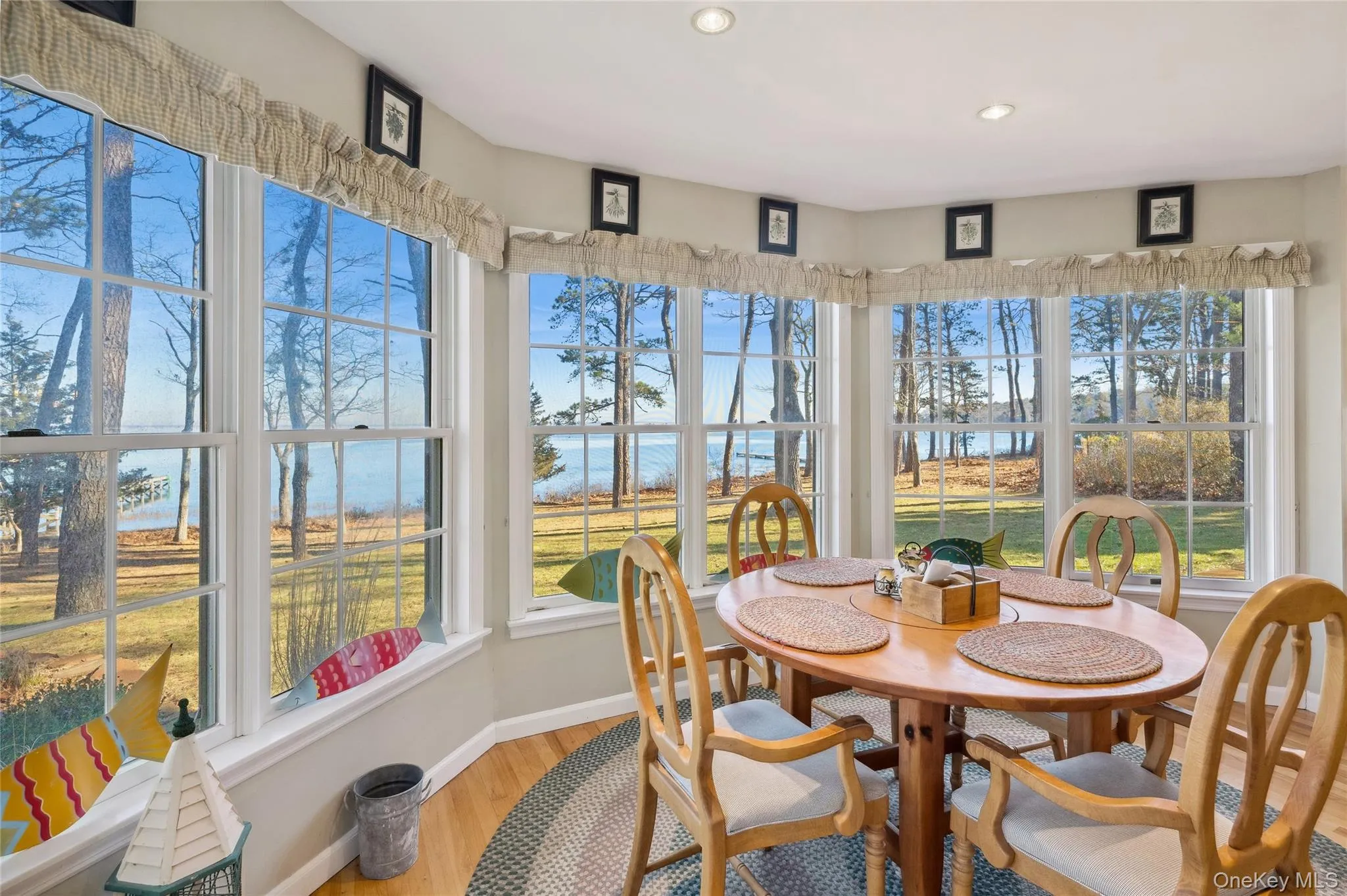 Sunroom / solarium featuring recessed lighting, wood finished floors, a water view, and baseboards Sunroom / solarium featuring recessed lighting, wood finished floors, a water view, and baseboards
