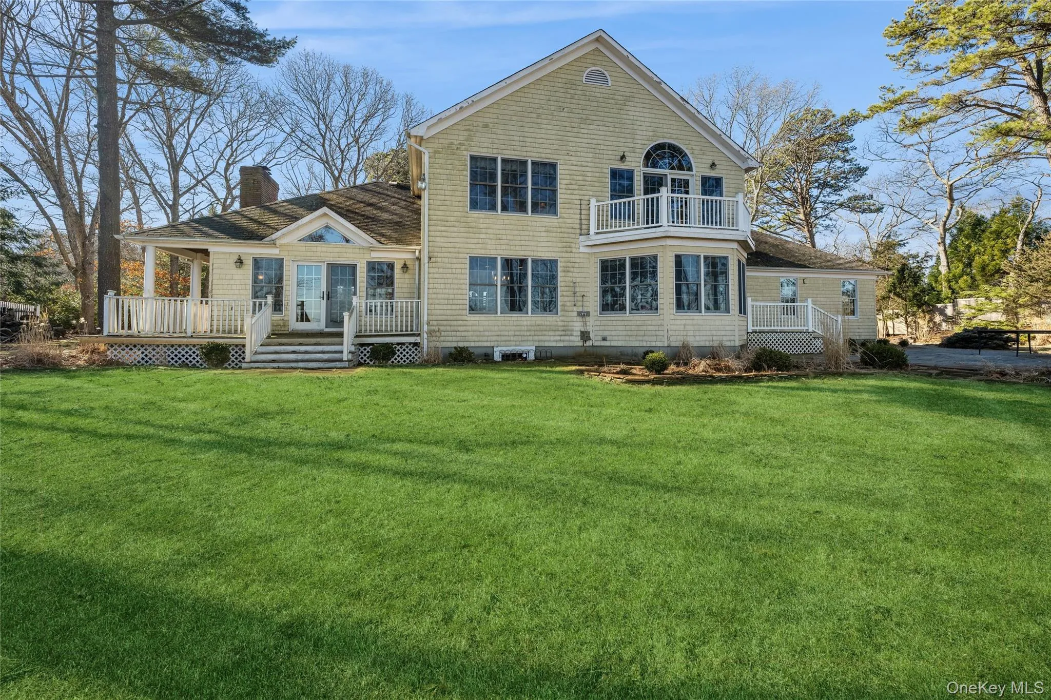 Rear view of property with a lawn, a chimney, and a balcony Rear view of property with a lawn, a chimney, and a balcony