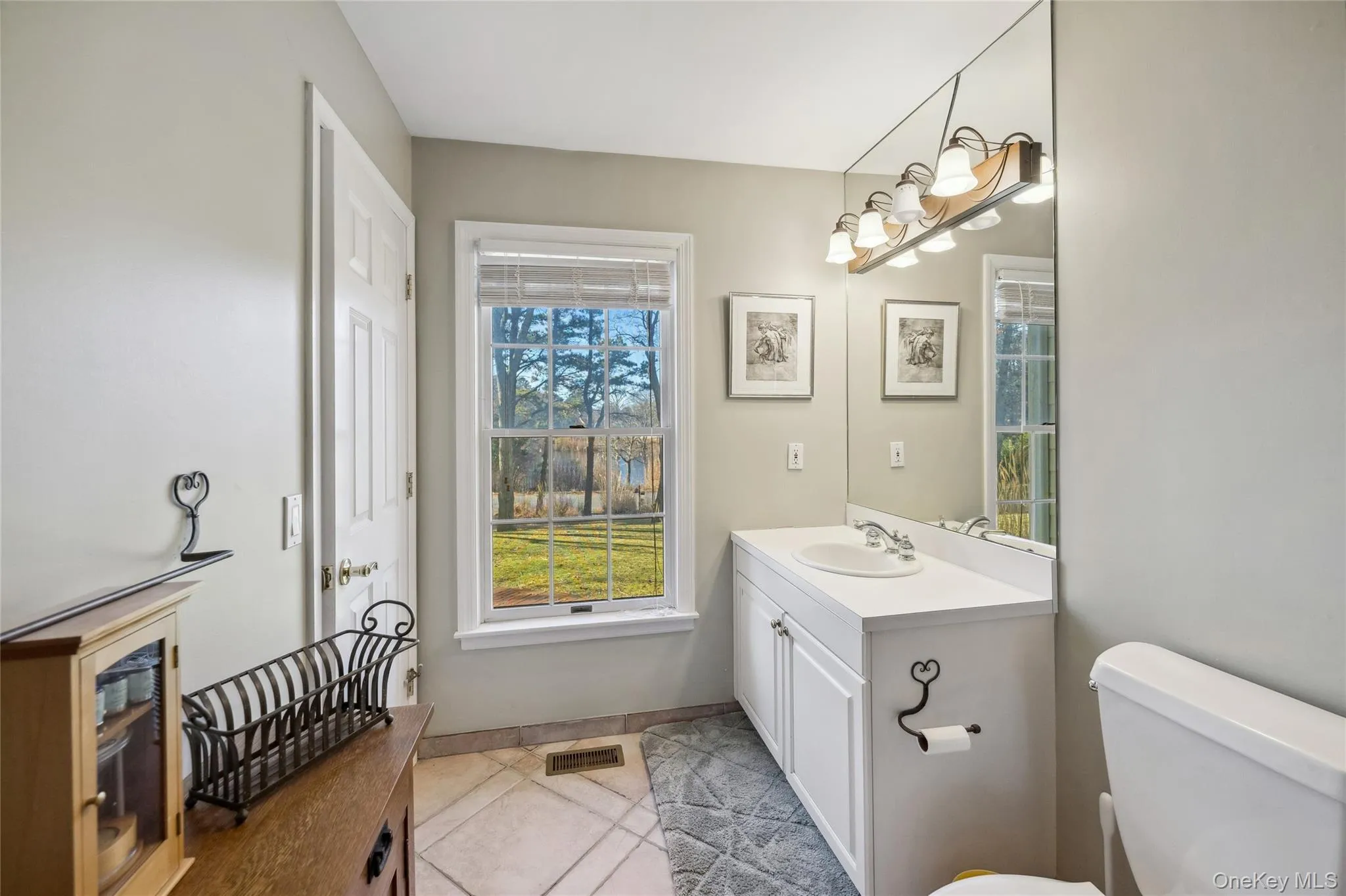 Bathroom featuring tile patterned floors, visible vents, toilet, vanity, and baseboards Bathroom featuring tile patterned floors, visible vents, toilet, vanity, and baseboards