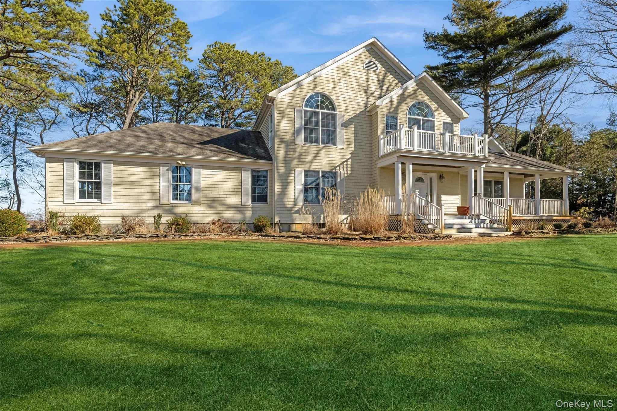 View of front of property with a porch, a front yard, and a balcony View of front of property with a porch, a front yard, and a balcony