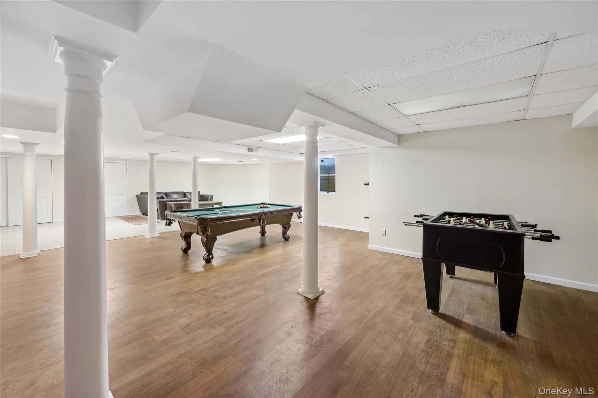 Rec room featuring a paneled ceiling, baseboards, wood finished floors, and pool table Rec room featuring a paneled ceiling, baseboards, wood finished floors, and pool table